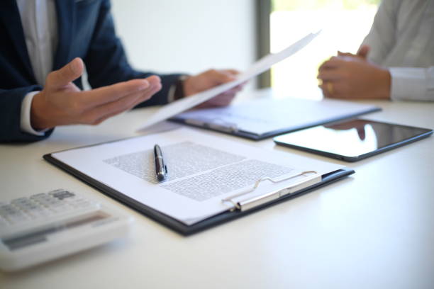 istock Sales manager giving advice application form document, considering mortgage loan offer for car and house insurance. 1556006125
