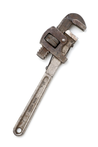 Antique pipe wrench, dirty, rusty, battered, isolated on white background.