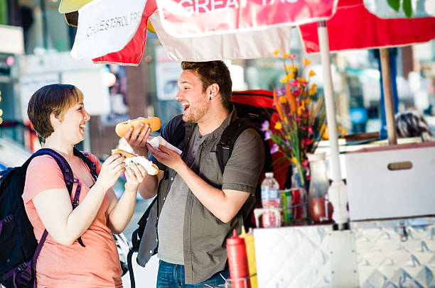 Backpackers in the City Young backpacker couple enjoying city life, Toronto. Canada. hot dog stand stock pictures, royalty-free photos & images