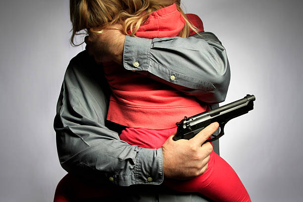 Family Protection Young child being embraced by a family member with a hanngun. baby gun stock pictures, royalty-free photos & images