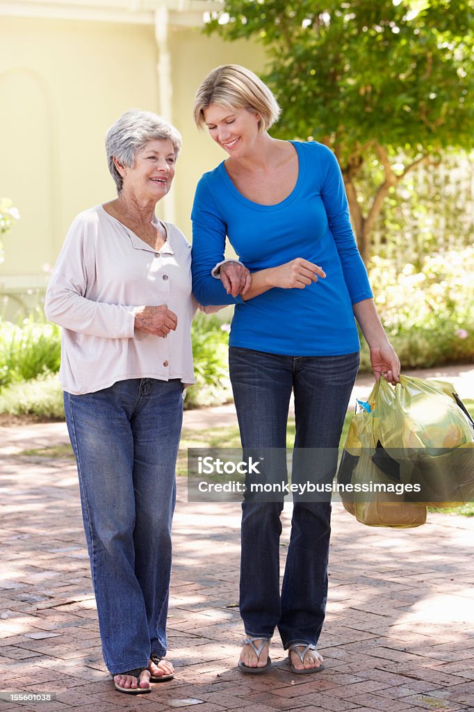 Donna aiutando Senior donna con lo Shopping - Foto stock royalty-free di Terza età