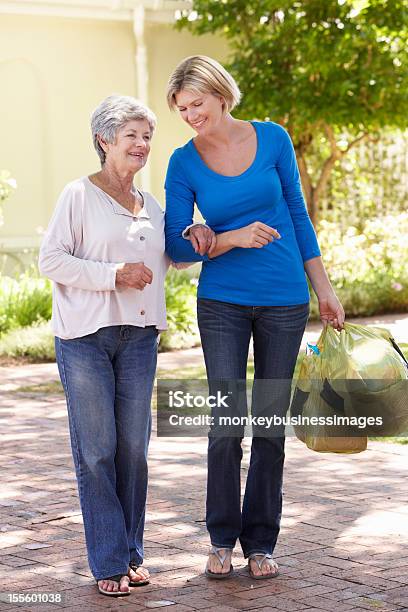 Donna Aiutando Senior Donna Con Lo Shopping - Fotografie stock e altre immagini di Terza età - Terza età, Assistente domiciliare, Camminare
