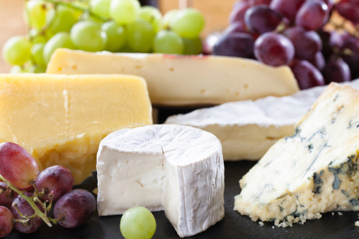 A selection of cheeses arranged on a slate cheese board.