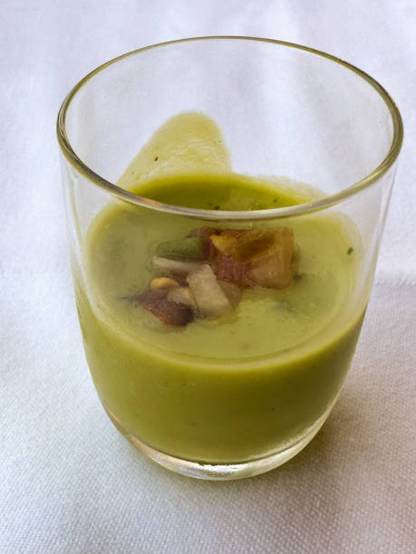 Amuse Bouche - guacamole soup A small welcome drink of a cold Amuse Bouche containing a cold spicy  avocado soup amuse stock pictures, royalty-free photos & images