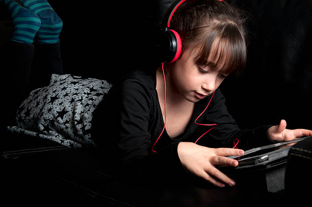 istock Girl with headphones playing w/ a digital tablet 155601519