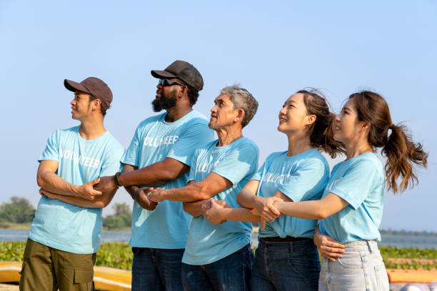 istock side view of volunteer team holding each other's crossed hands for unity and teamwork 1556018017