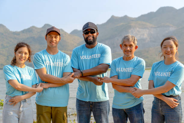 istock volunteer team holding each other's crossed hands for unity and teamwork 1556018021