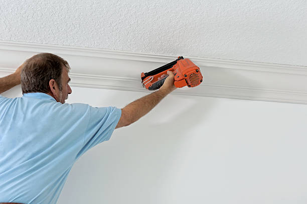 Construction: Installing crown molding carpenters installing crown molding architectural cornice stock pictures, royalty-free photos & images