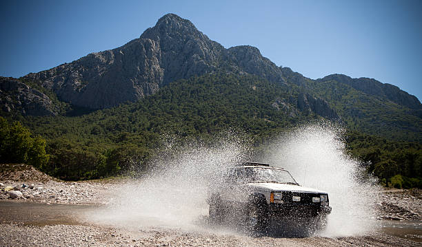 jeep, werfen das wasser bach auf der durchreise - vierradantrieb stock-fotos und bilder