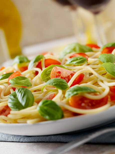 Pasta with Fresh Basil and Tomatoes  cooked selective focus vertical pasta stock pictures, royalty-free photos & images
