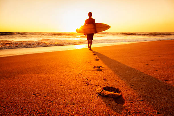 zachód słońca surferka - men footprint beach sunset zdjęcia i obrazy z banku zdjęć