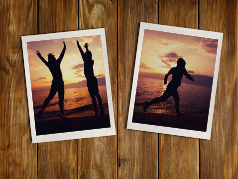 Polaroid films, young girl and boy running along the beach in the summer dawn. on wood wall. Close-up. Studio shot.