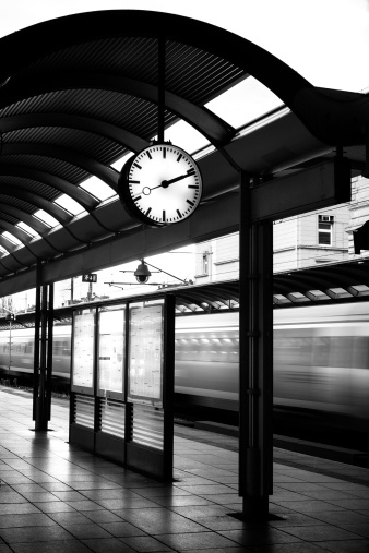 Time table, clock and passing by train - toned image