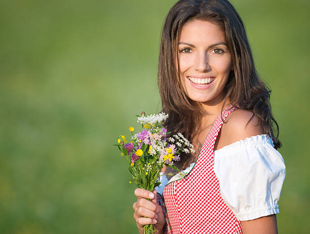 dirndl moda hermosa mujer sosteniendo un ramo de flores (xxxl) - dirndl traditional clothing austria traditional culture fotografías e imágenes de stock