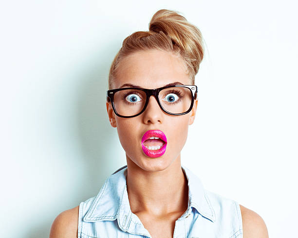 Shocked woman Portrait of shocked young woman looking at the camera. Studio shot. women screaming surprise fear stock pictures, royalty-free photos & images