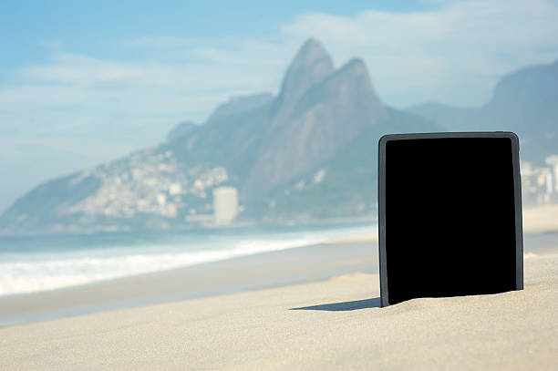 tablette numérique ordinateur se dresse sur la plage d'ipanema à rio de janeiro - computer monitor nobody two brothers mountain travel destinations photos et images de collection