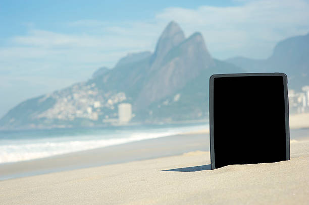 цифровой планшетный компьютер стоит на пляж ипанема в рио-де-жанейро - computer monitor nobody two brothers mountain travel destinations стоковые фото и изображения