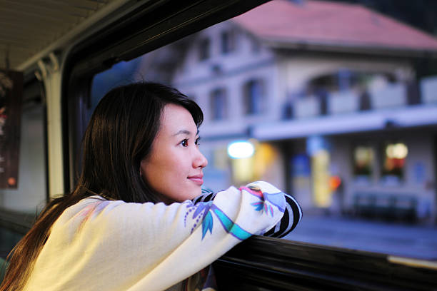 frau gespannt und schaut durch fenster-xl - leaving loneliness women railroad track stock-fotos und bilder