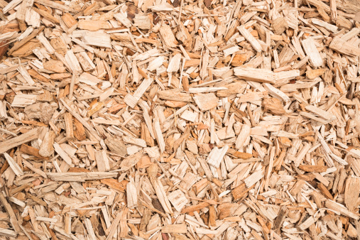 A background of wood chips, prepared as fuel for a biomass boiler.