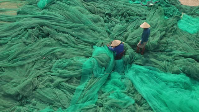 2 man knitting fishing net in Hon Ro dock
