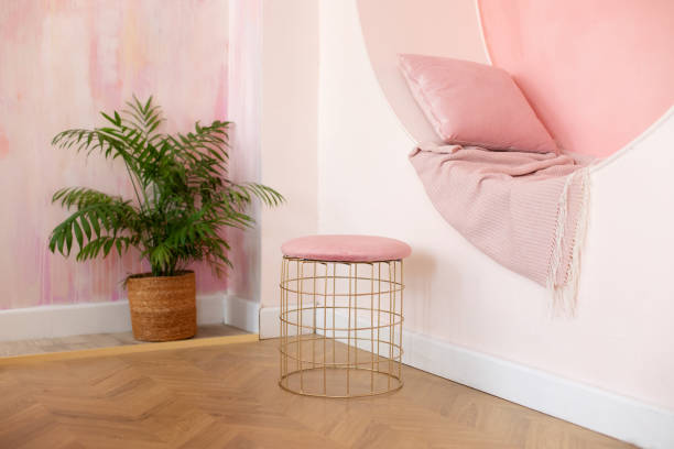 istock Modern Living room design vibrant interior with decorative arch on pink wall with pillows and plaid. Memphis style interior with niche arch and pouf for seat. Modern style conceptual interior room 1556035649
