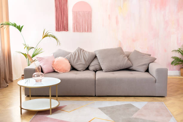 istock Cozy living room interior design with stylish grey sofa, pillows and coffee table with bouquet of dried flowers in modern scandinavian home. Modern room interior with comfortable sofa and furniture 1556035707