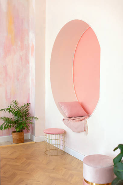 istock Modern style conceptual interior room. Modern Living room design vibrant interior with decorative arch on pink wall with pillows and plaid. Memphis style interior with niche arch for seat. Arch window 1556036284