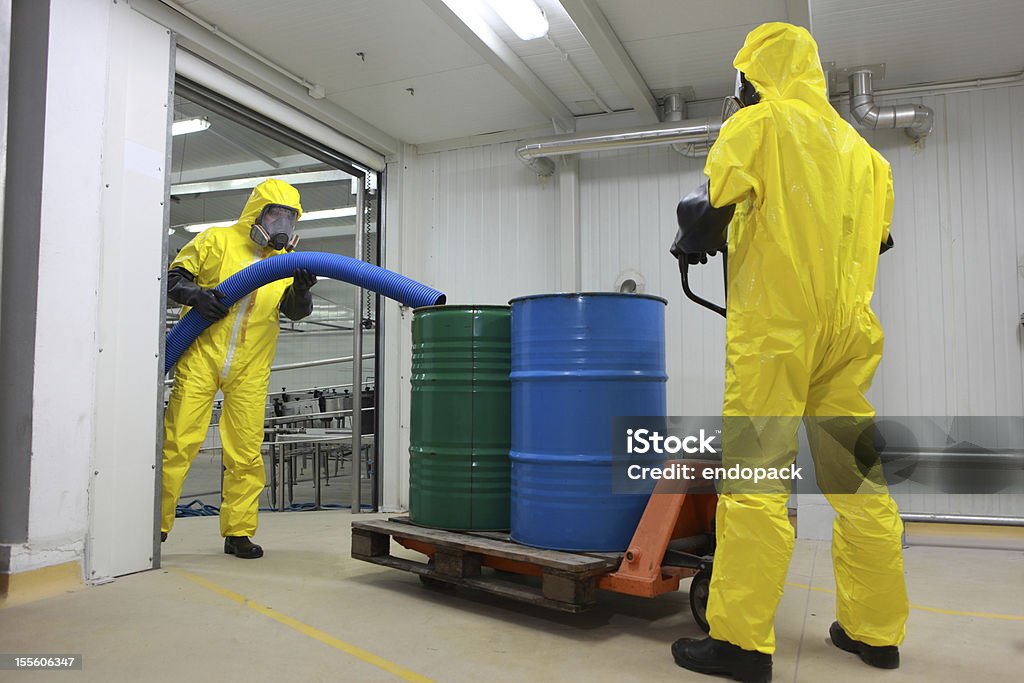 Dwóch specjalistów w stroje postępowanie z chemicalss - Zbiór zdjęć royalty-free (Odpady toksyczne)