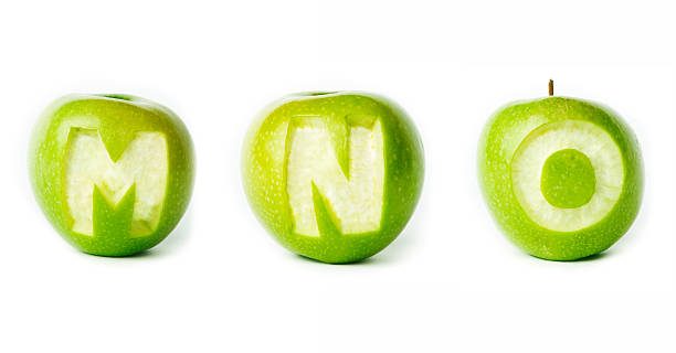 新鮮なグリーンアップルまでつながっているようです。 - letter m alphabet food fruit ストックフォトと画像