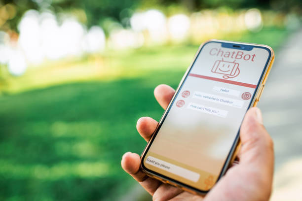 istock Man talking to a chatbot with voice commands using smartphone. Robot service assistant,  modern artificial intelligence, futuristic innovation and technology concept. 1556105269