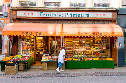 Ville-Haute, Luxembourg-May 26, 2023; View of traditional façade of a green grocer store with member of staff taking care of fruits and vegetable displayed outside the store