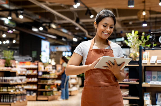 istock Retail clerk using a tablet while working at the supermarket 1556120379