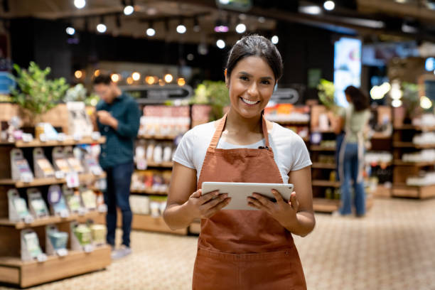 istock Retail clerk working at a supermarket using a tablet 1556120390