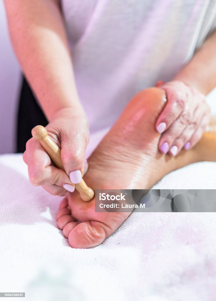 Masseur doing a reflexology foot massage in a spa Vertical close-up photo of the hands of a masseur doing a reflexology foot massage in a spa 30-34 Years Stock Photo