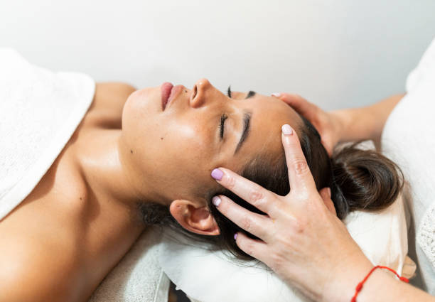 entspannte frau, die eine spa-massage des kopfes bekommt - head massage flash stock-fotos und bilder