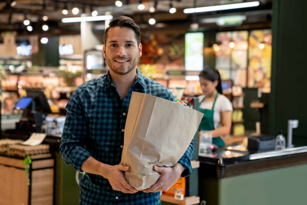 istock Man carrying a shopping bag while leaving the supermarket 1556146731