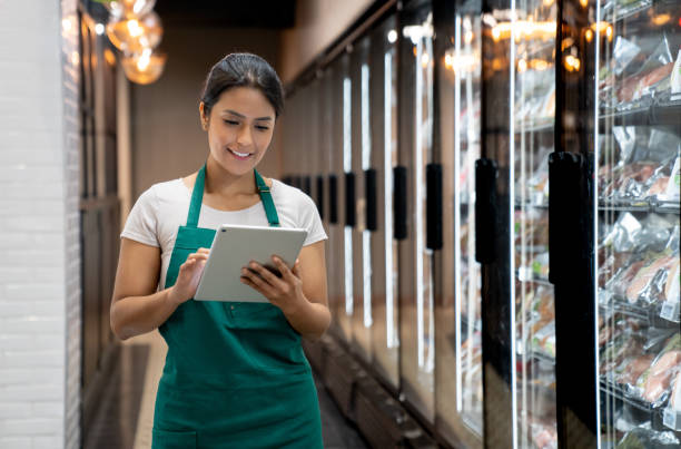 istock Retail clerk working at a supermarket using a digital tablet 1556146732