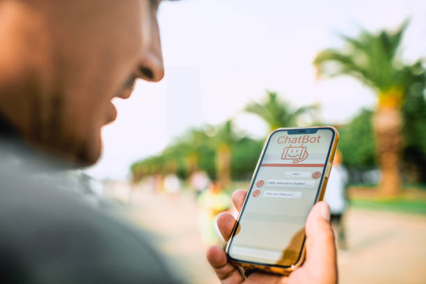 istock Man talking to a chatbot with voice commands using smartphone. Robot service assistant,  modern artificial intelligence, futuristic innovation and technology concept. 1556160123