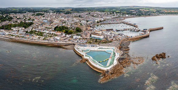 Aerial panorama landscape of the Cornish coast town of Penzance from the ocean with harbour and Jubilee swimming pool and copy space