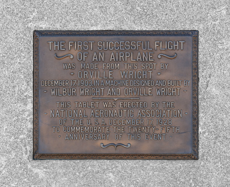 Kill Devil Hills, NC, USA - March 7, 2023: A plaque at the Wright Brothers National Memorial in Kill Devil Hills, North Carolina. The Wright Brothers National Memorial commemorates the first successful, sustained, powered flights in a heavier-than-air machine.