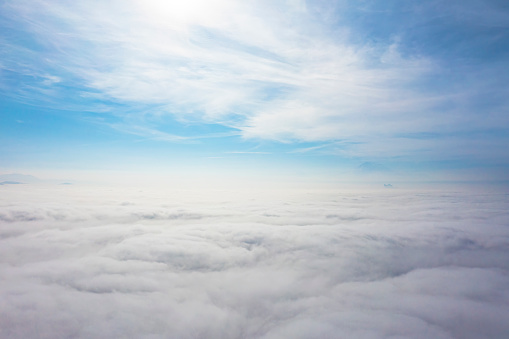 Aerial top view cloudscape. Texture of clouds. View from above. Sunrise or sunset over clouds in sunny weather