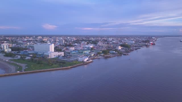 Demerara River, Georgetown Guyana - Reveal Shot - Aerial 
- Demerara River from the Atlantic Ocean
Revealing the capital city of Guyana. 

A fishing boat travels up the Demerara River after a day's catch.