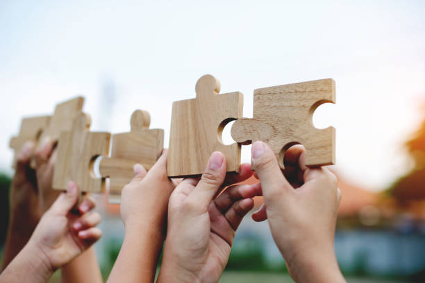istock Jigsaw puzzle in hand, teamwork together communication puzzle piece teamwork concept 1556246626