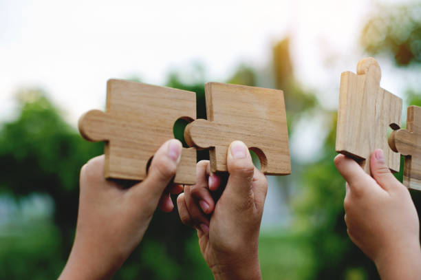 istock Jigsaw puzzle in hand, teamwork together communication puzzle piece teamwork concept 1556246629