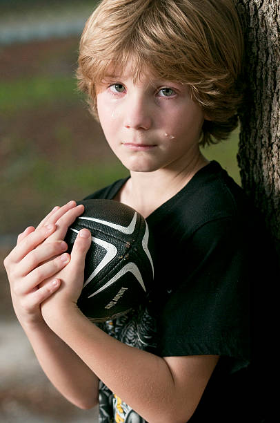 Boy crying holding a football