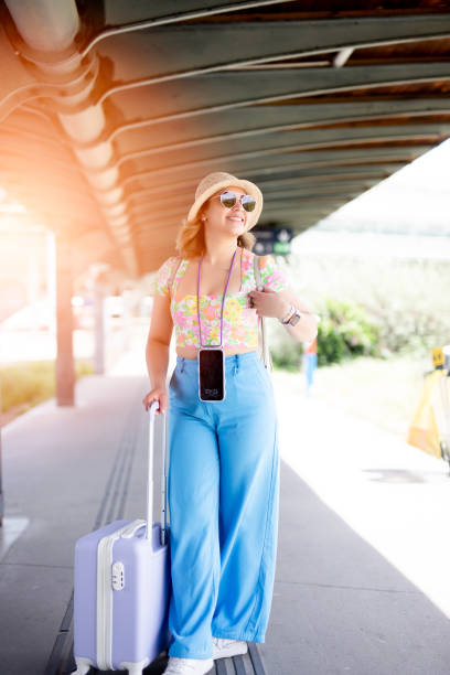istock Happy young woman at train station 1556291394