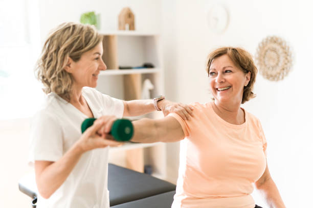 istock Physiotherapist working with elderly patient in clinic 1556301565