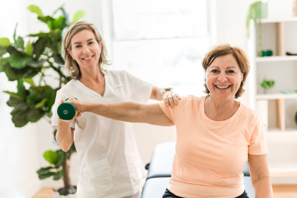 istock Physiotherapist working with elderly patient in clinic 1556301570