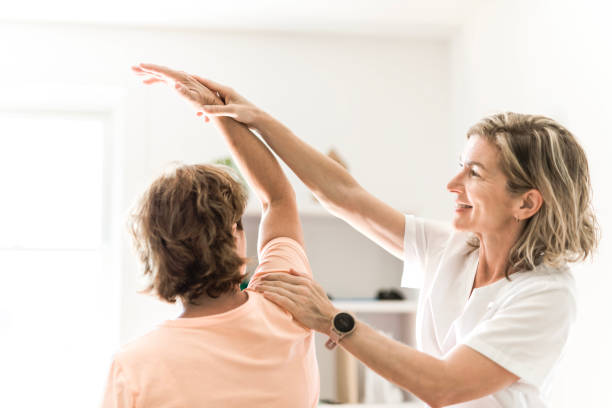 istock Physiotherapist working with elderly patient in clinic 1556301584