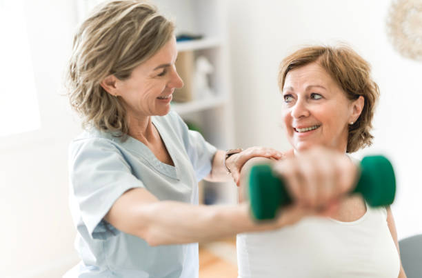 istock Physiotherapist working with elderly patient in clinic 1556302663